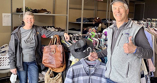 Two Clothing Closet workers smiling with clothing donated for CISS community members.